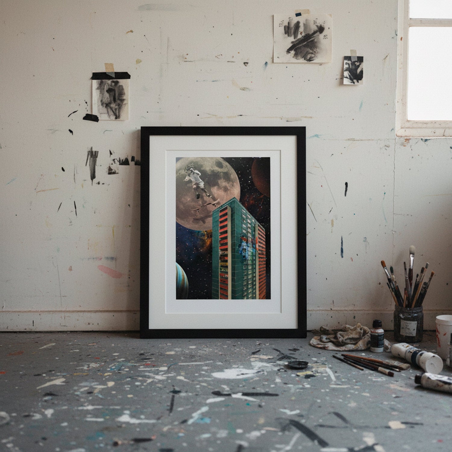 Framed artwork on a messy artist's studio wall with paint splatters.