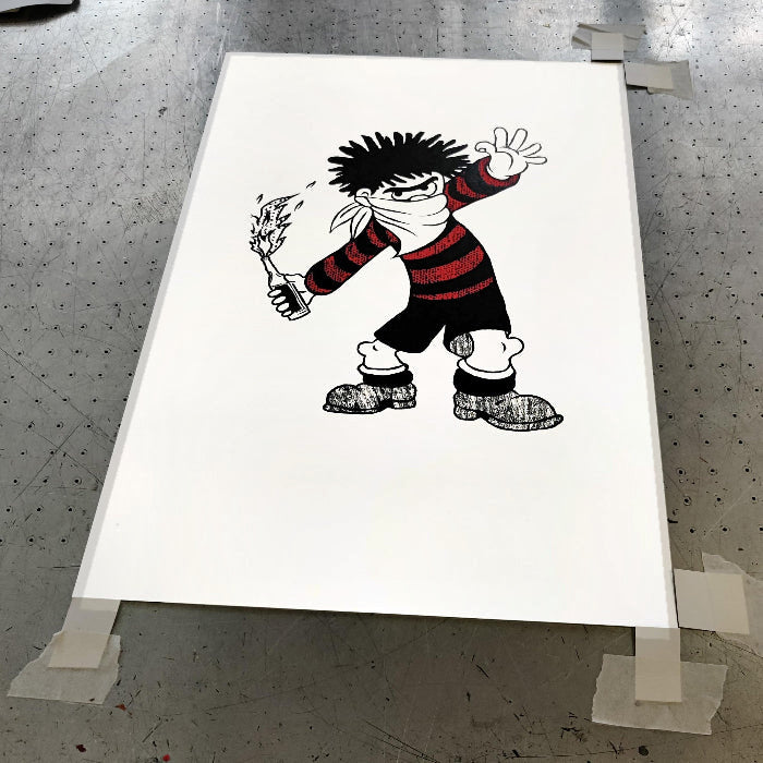 Molotov Dennis artwork by Gerard McDonagh, showing a black-and-red comic character holding a flaming bottle, shown on paper.